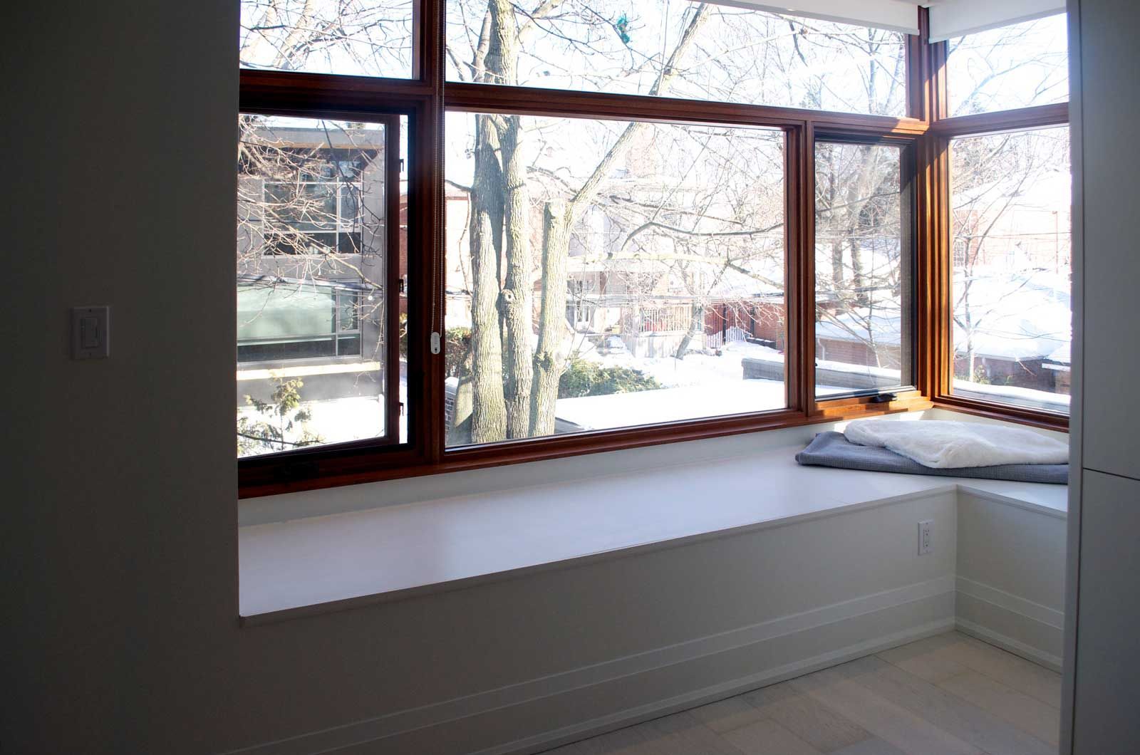 A window seat in a room with a view of trees