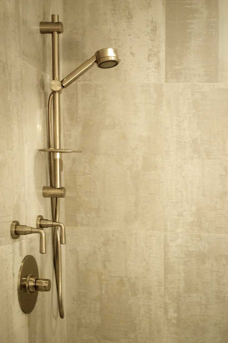 A close up of a shower head in a bathroom.