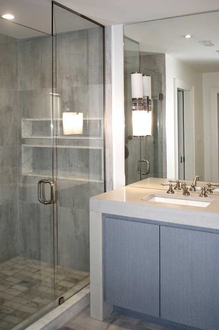 A bathroom with a walk in shower and a sink