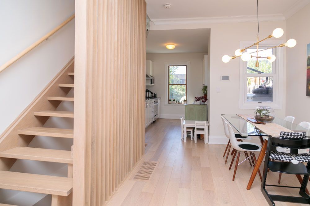 A staircase leading up to a dining room with a table and chairs.