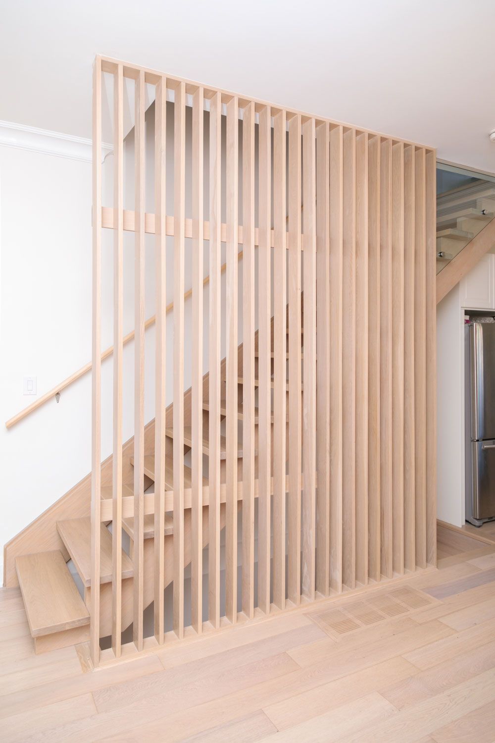A wooden staircase with a wooden railing in a room.