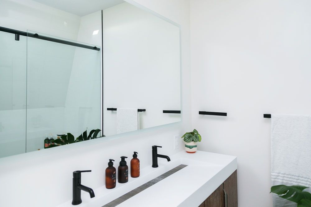 A bathroom remodel with two sinks and a large mirror