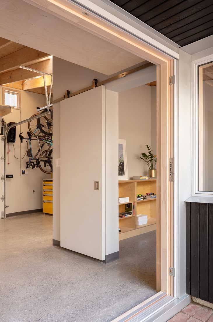 A garage with a sliding glass door and a bicycle hanging on the wall.