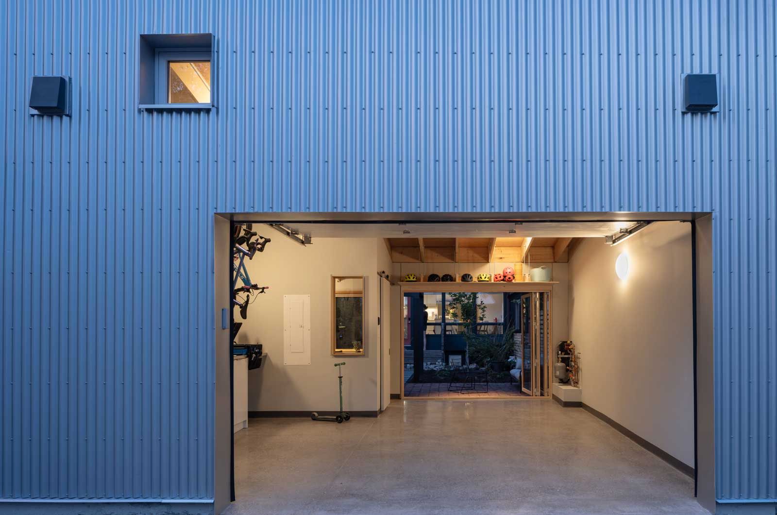 A garage with a door open and a window on the side of it.