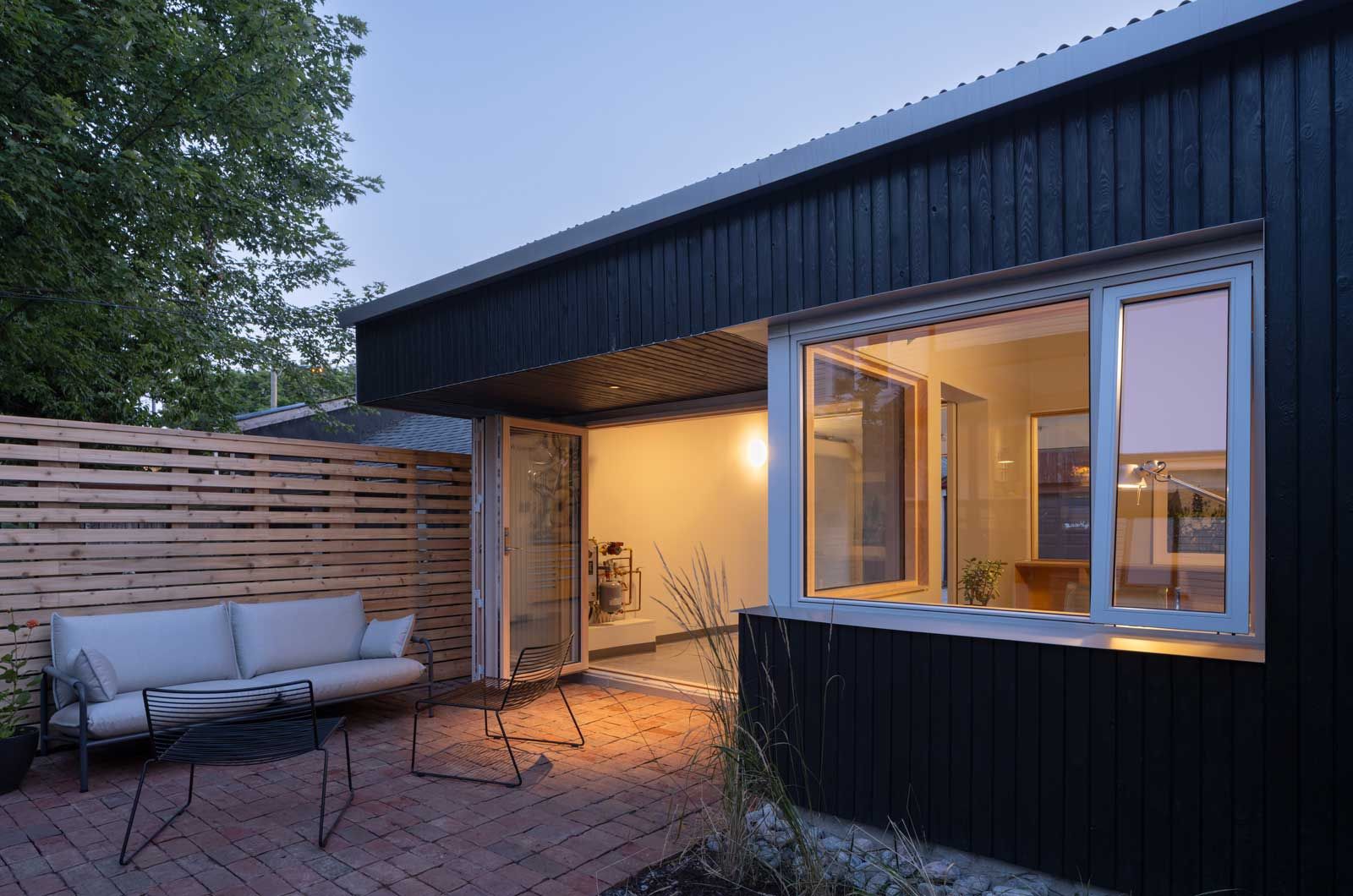 A small house with a patio and a couch in front of it.
