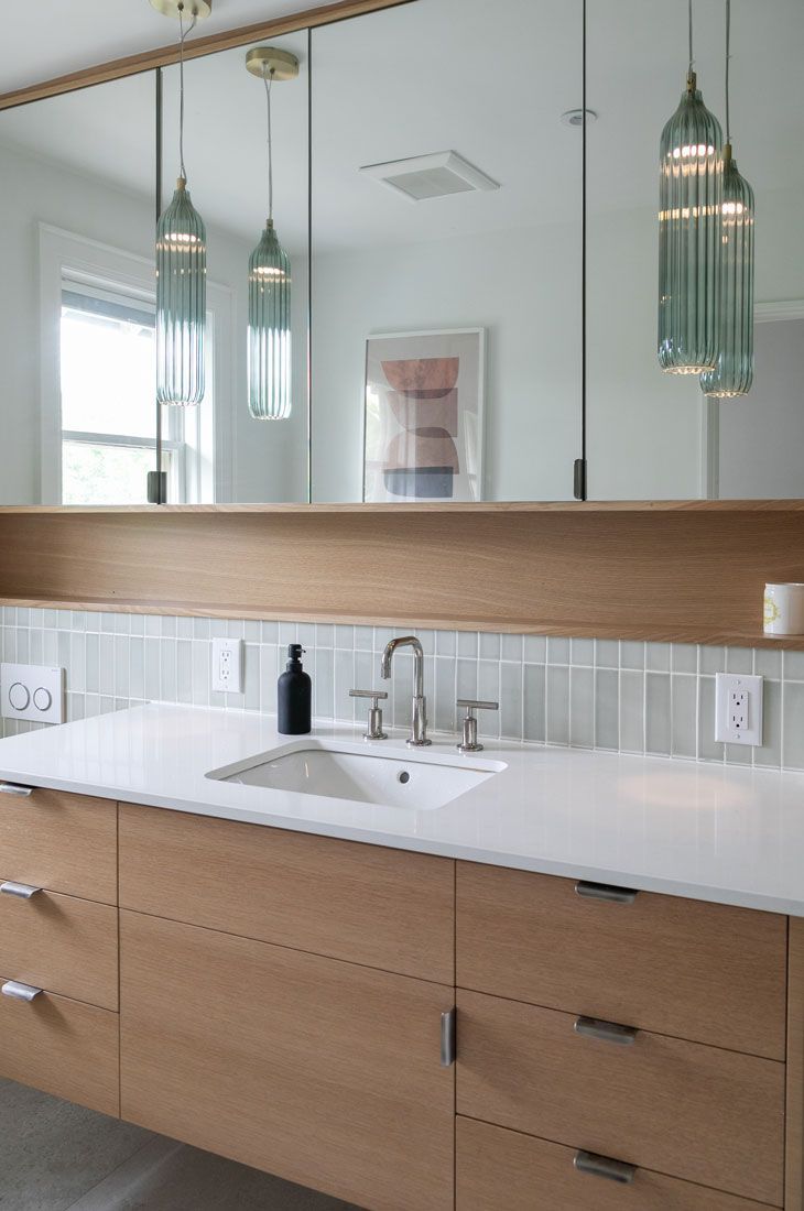 A bathroom remodel with a sink and a large mirror