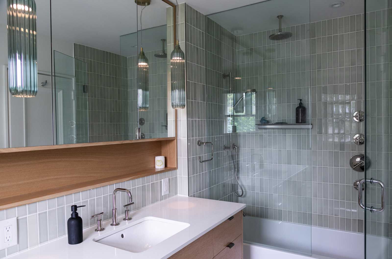 A bathroom remodel with a sink, tub, shower, and mirror.