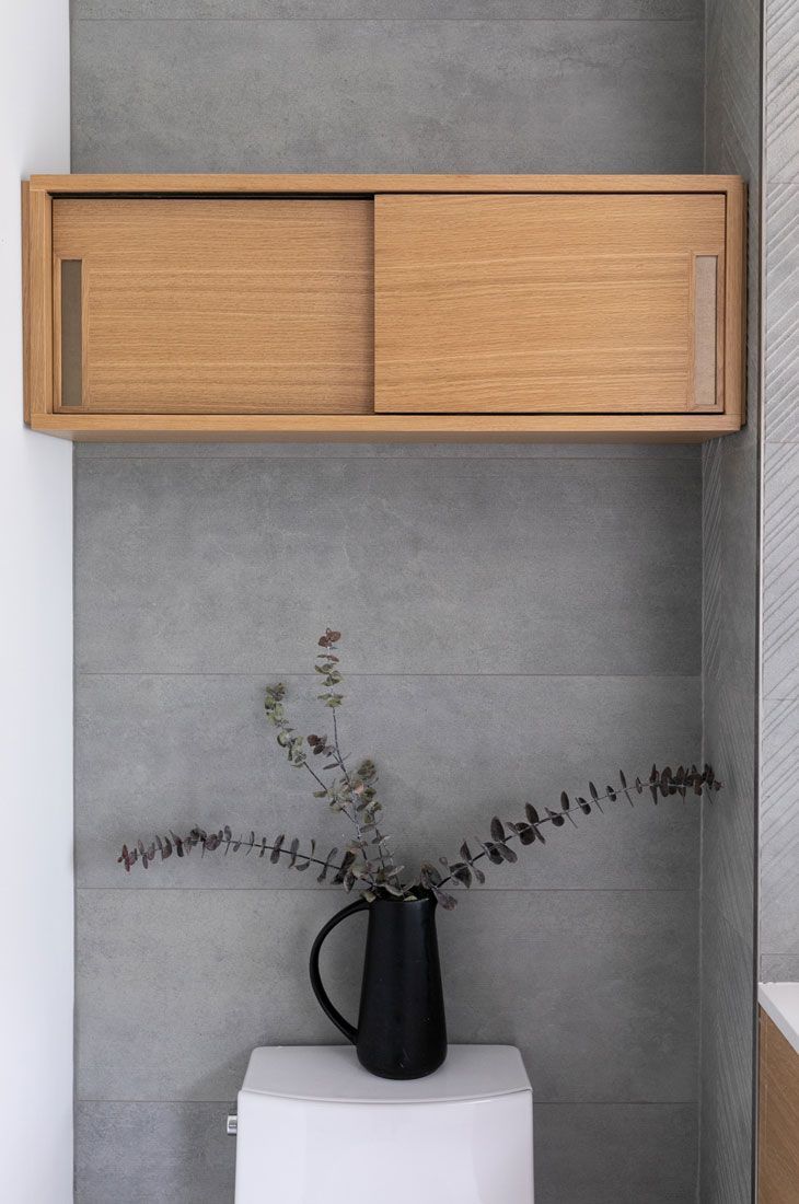 A vase of flowers is sitting on top of a toilet in a bathroom remodel.