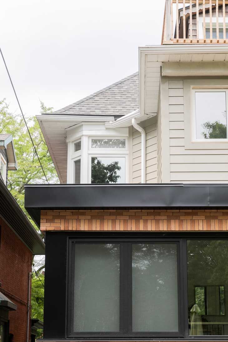 A house with a balcony and a large window on the side of it.