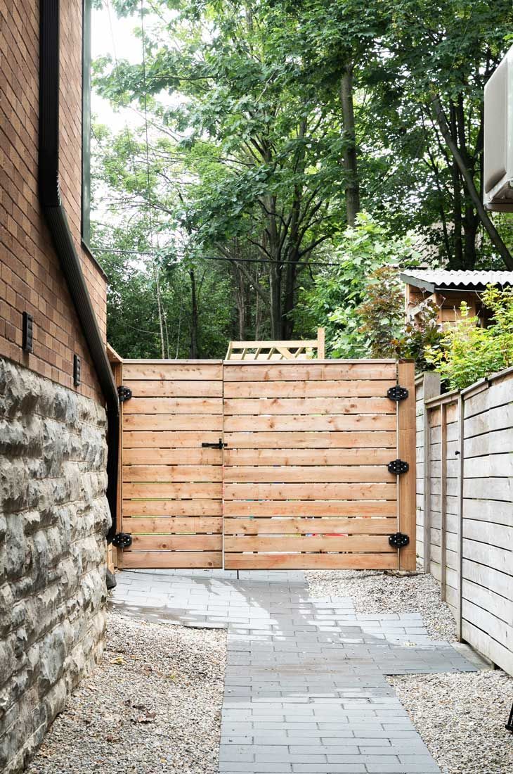 There is a wooden gate between two buildings.