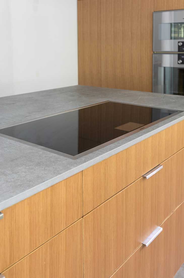 A kitchen with wooden cabinets and a stove top oven.