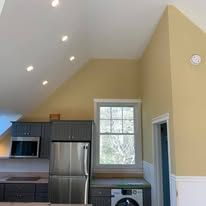 A kitchen with a refrigerator , washer and dryer , and a window.