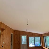 A living room with wood paneling and a white ceiling.