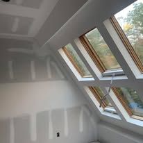 A room with a lot of windows and a ceiling that is being remodeled.