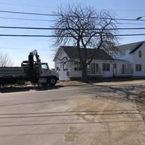 A truck is parked on the side of the road in front of a house.