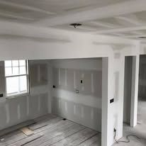 A room with drywall on the walls and a window.