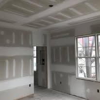 A room with drywall on the walls and a window.