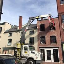 A crane is being used to remove a window from a building.