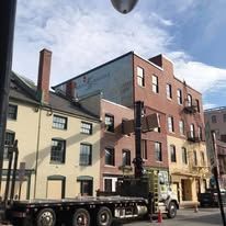 A truck is parked in front of a row of buildings.