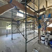 A large empty room with scaffolding in the middle of it.