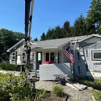 A house is being remodeled with a crane in front of it.