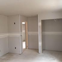 An empty room with drywall on the walls and a door.