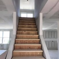 A set of wooden stairs leading up to the second floor of a house under construction.
