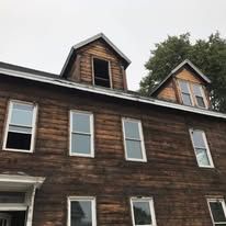 A large wooden house with a lot of windows and a roof.