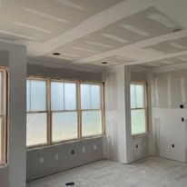 A room with a lot of windows and drywall on the ceiling.
