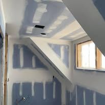 A room with a window and a ceiling that is being remodeled.