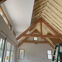 A room with a ladder in it and a roof that is being insulated.