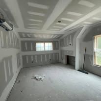 An empty room with drywall on the walls and ceiling.