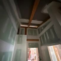 A hallway with a ceiling that is being remodeled in a house.
