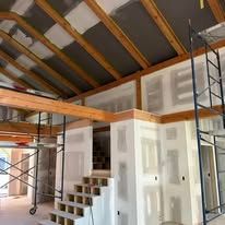 A room with stairs and scaffolding in it is being remodeled.