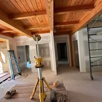 A room with a wooden ceiling and a ladder in it.