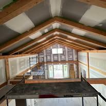 The inside of a house under construction with a wooden ceiling.