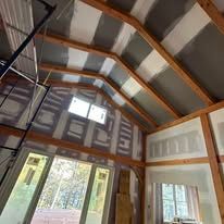 A room with a ceiling that is being built and a lot of windows.