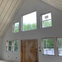 A large room with a lot of windows and a wooden ceiling.