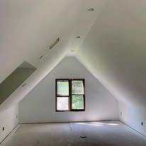 There is a window in the attic of a house.
