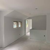 An empty room with white walls and a ceiling.