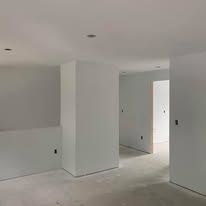 An empty room with white walls and a concrete floor.