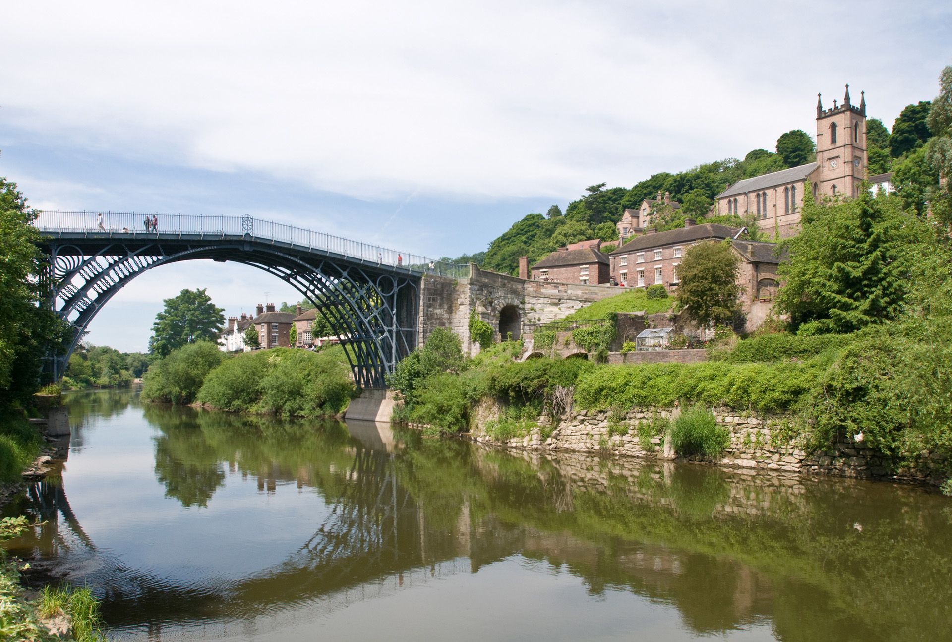 A bridge over a river with a church in the background