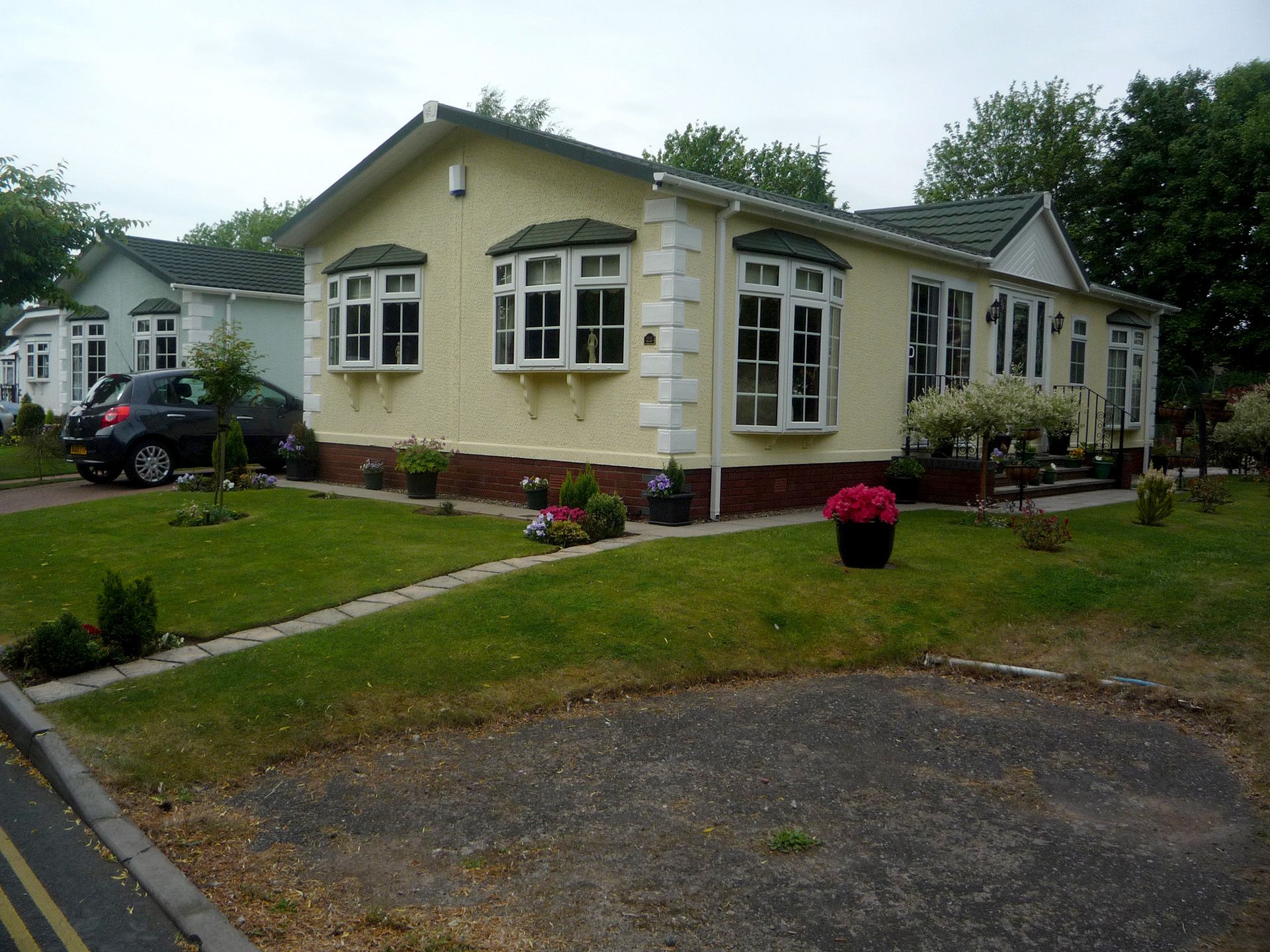 AView of a group of ducks sitting on the shore of a river next to Cotswold Grange Country Park holiday homes