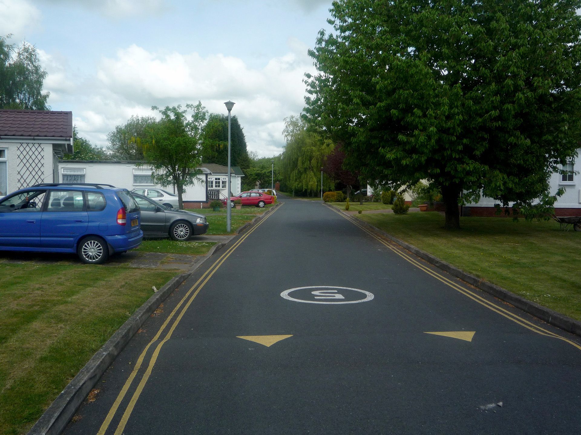 A blue car is parked on the side of the road