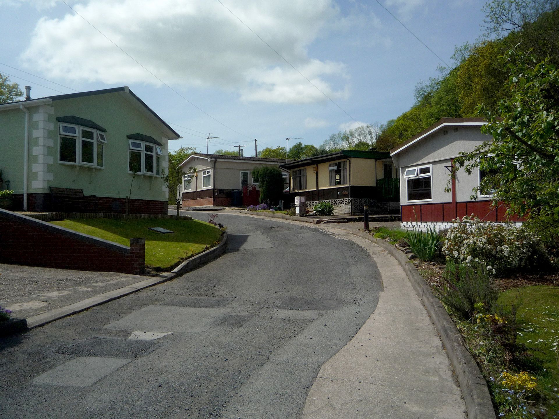 A row of mobile homes are lined up on the side of a road