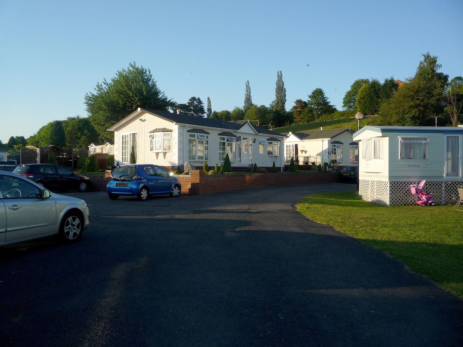 A lot of cars are parked in front of a row of houses