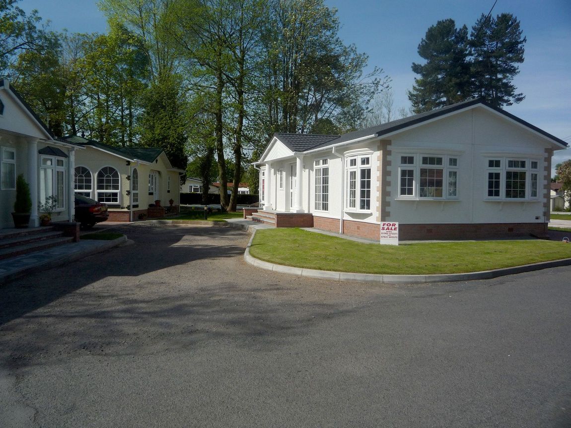 A white house with a sign that says ' for sale ' on it