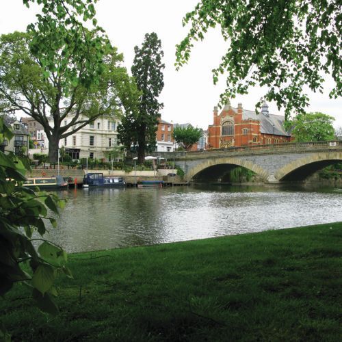 A bridge over a river with buildings in the background