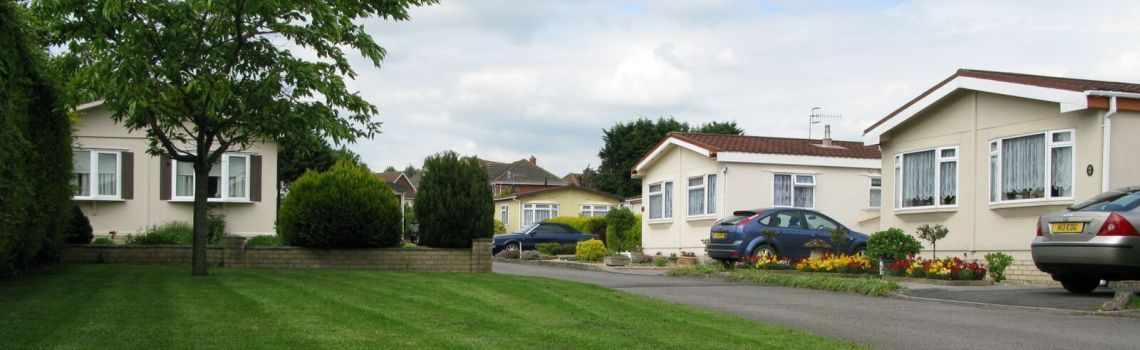 A row of houses with cars parked in front of them