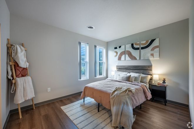 A bedroom with a large bed , a rug , and a ladder.